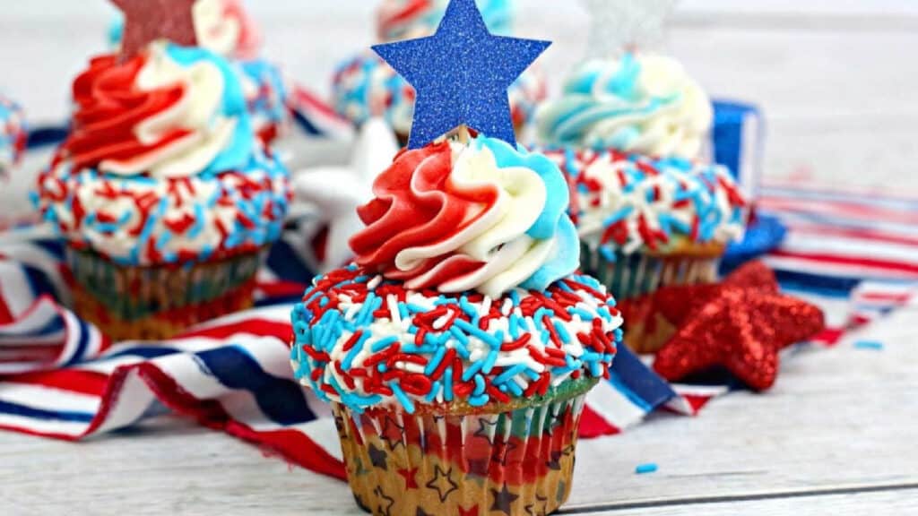 Cupcakes with red, white and blue sprinkles on top and a paper star.