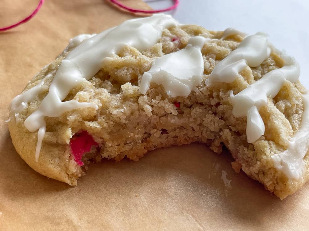 A rhubarb cookie with a bite take out of it on a piece of parchment paper.