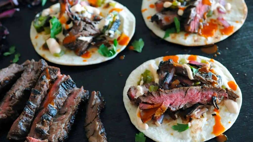 Sliced skirt steak and tacos.