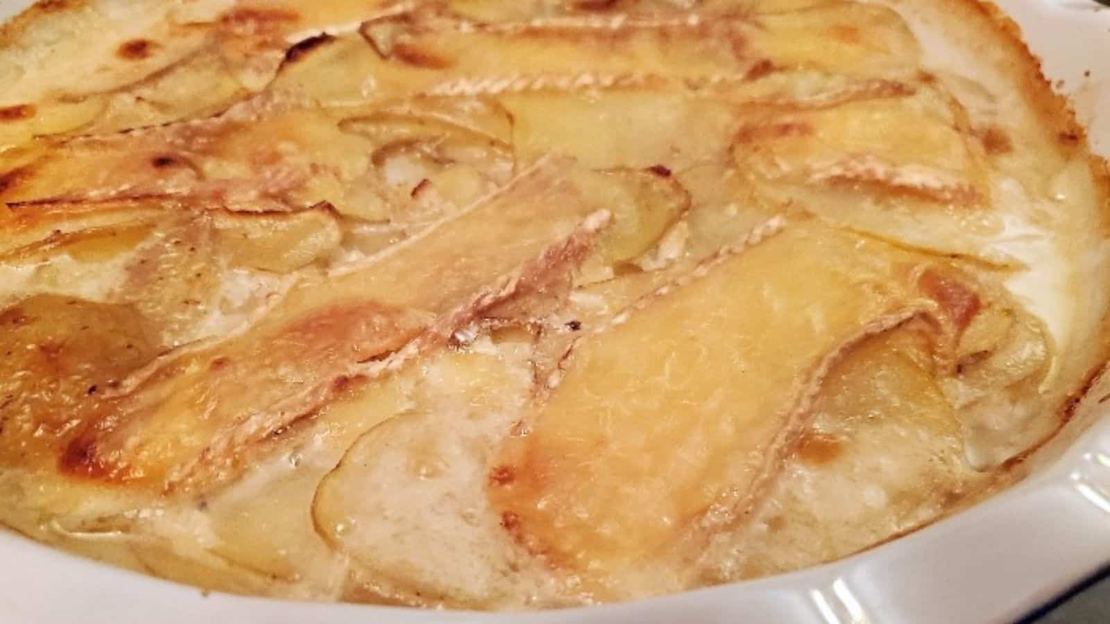 Image shows a closeup of a casserole of Smoked Brie Potato Gratin.