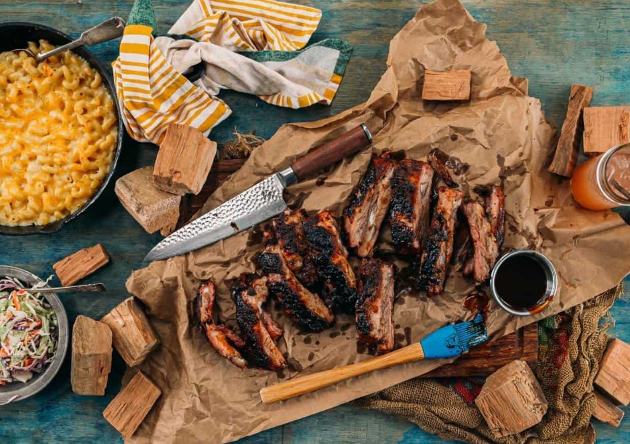 Overhead shot of rustic table with sliced ribs and sides.