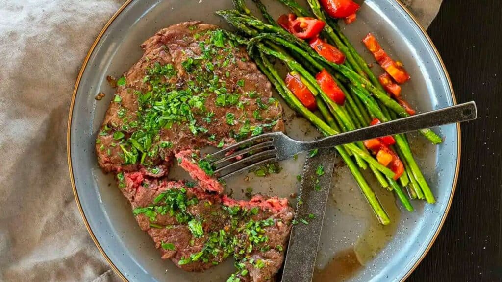 Steak Diane on plate with asparagus.