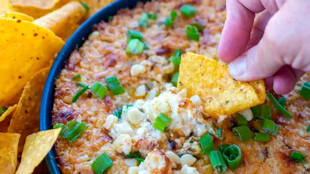 tortilla chip dipped into street corn dip.