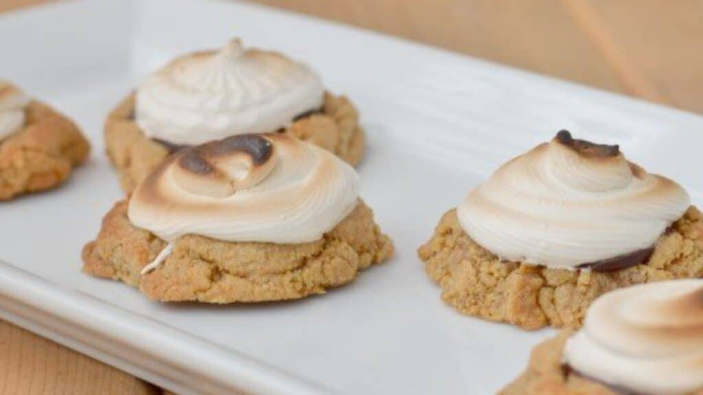 Image shows Toasted smores cookies on a white tray.
