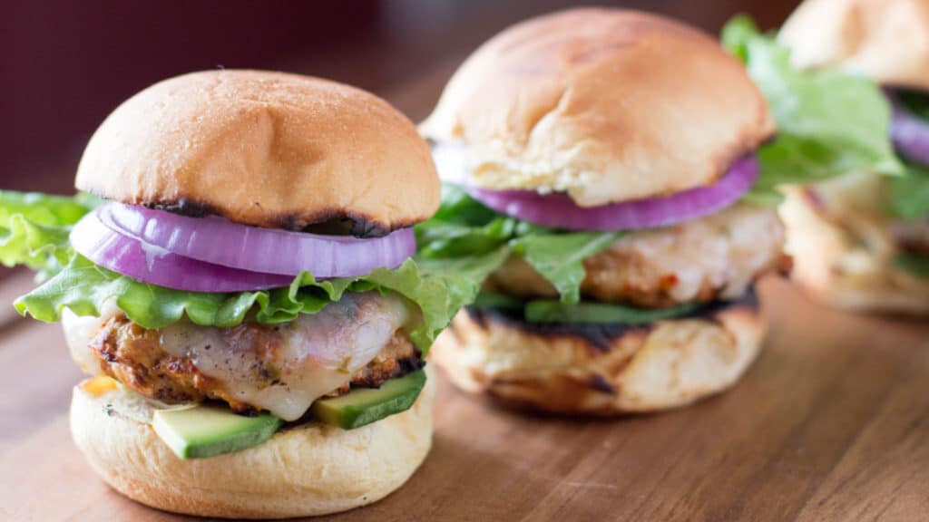 Two turkey sliders on a wooden board.