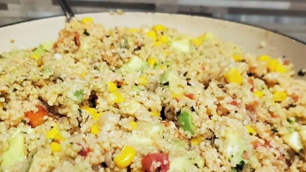 Image shows a close up shot of Vegan couscous salad in an enameled cast iron pan.