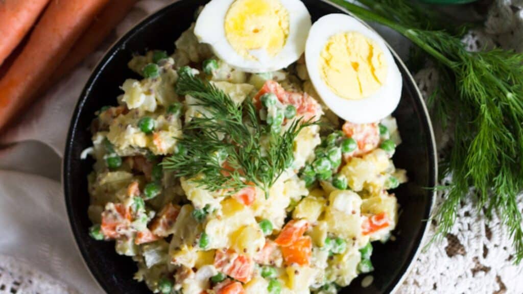 overhead view of olivier salad with two egg halves.