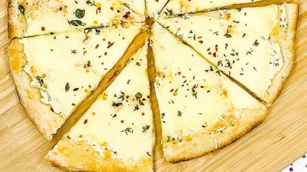 Sliced white pizza on a pizza board.