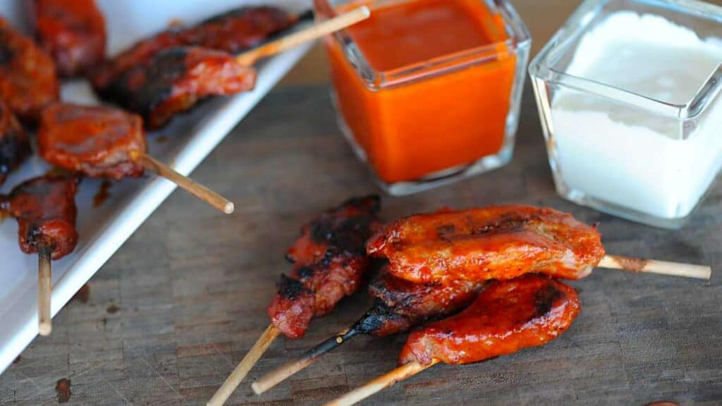 Buffalo pig wings on a platter with buffalo sauce.