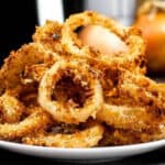 Pile of onion rings on a white plate.