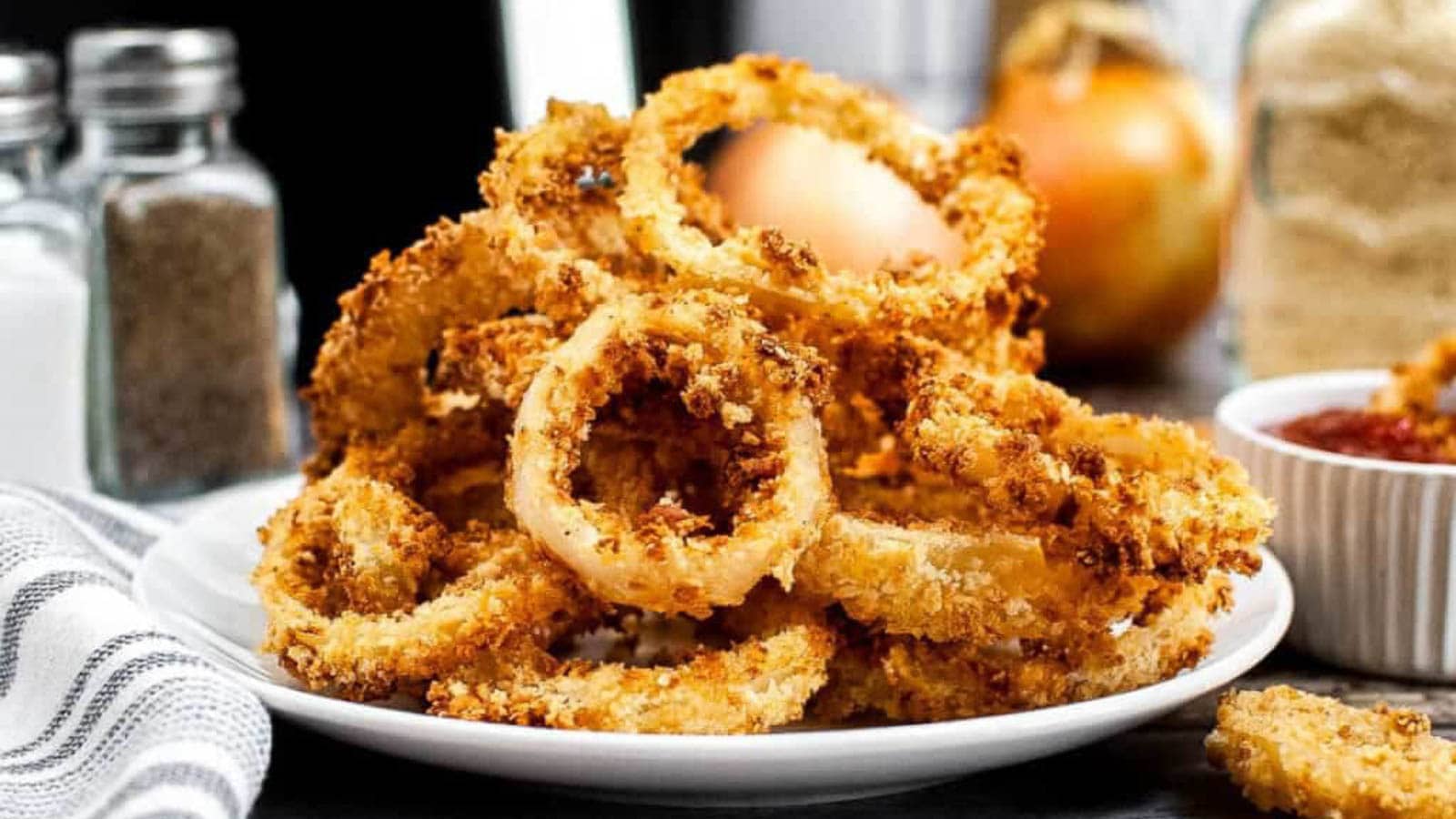 Pile of onion rings on a white plate.
