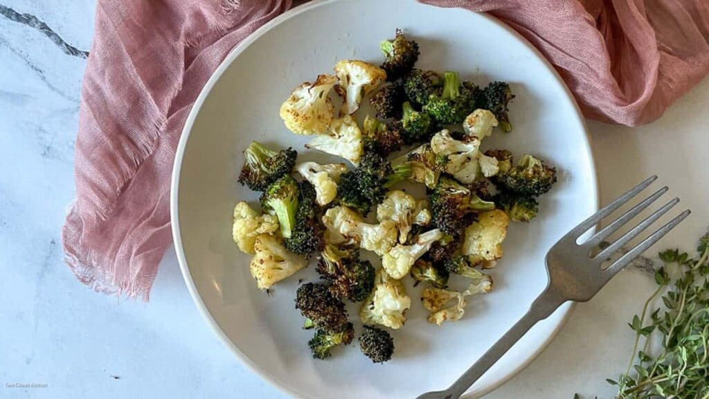 Air fryer broccoli and cauliflower on a white plate.