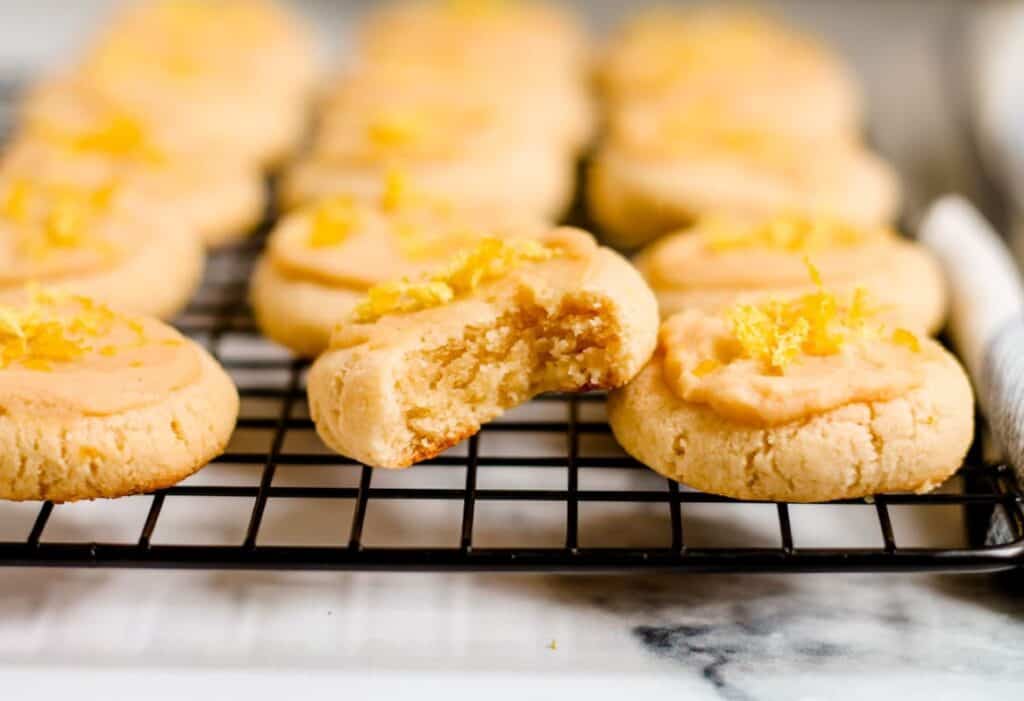A wire rack with lemon cookies on it.