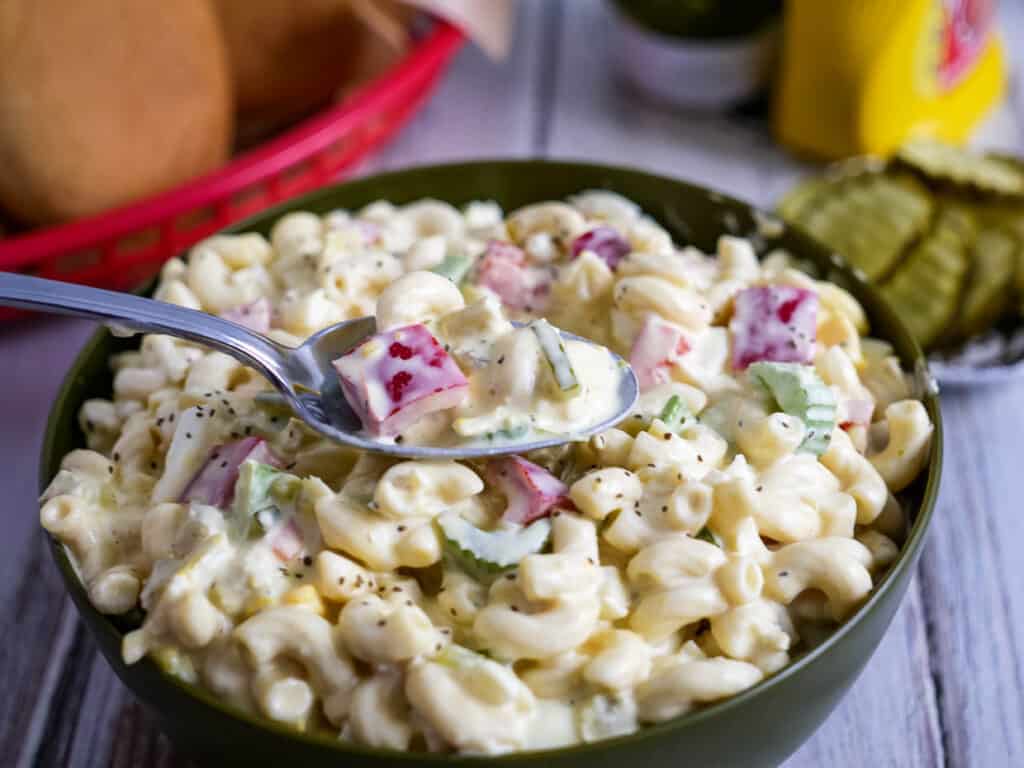 Bowl of Amish macaroni salad with some on a spoon.