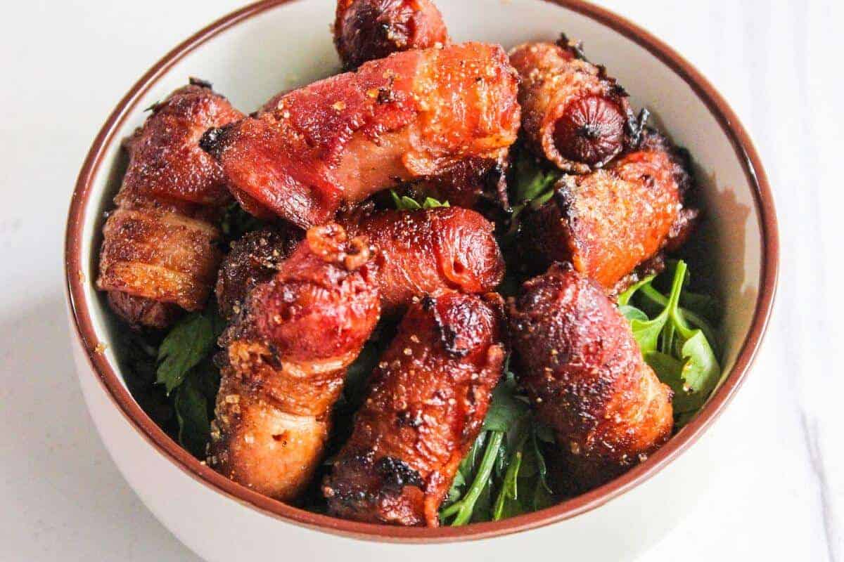Bowl of bacon wrapped cocktail sausages.