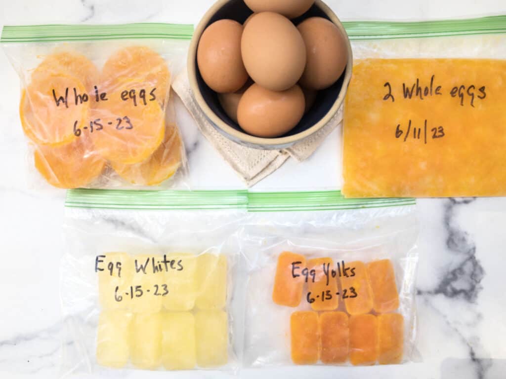 Four bags of frozen eggs in differnt forms with handwritten lables and dates.