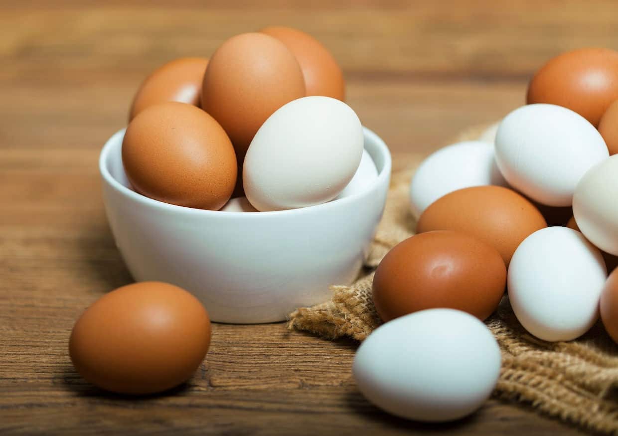 A white bowl with brown and white eggs.