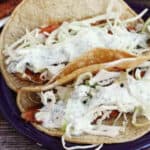 Fish tacos with shredded cabbage and cilantro lime crema.