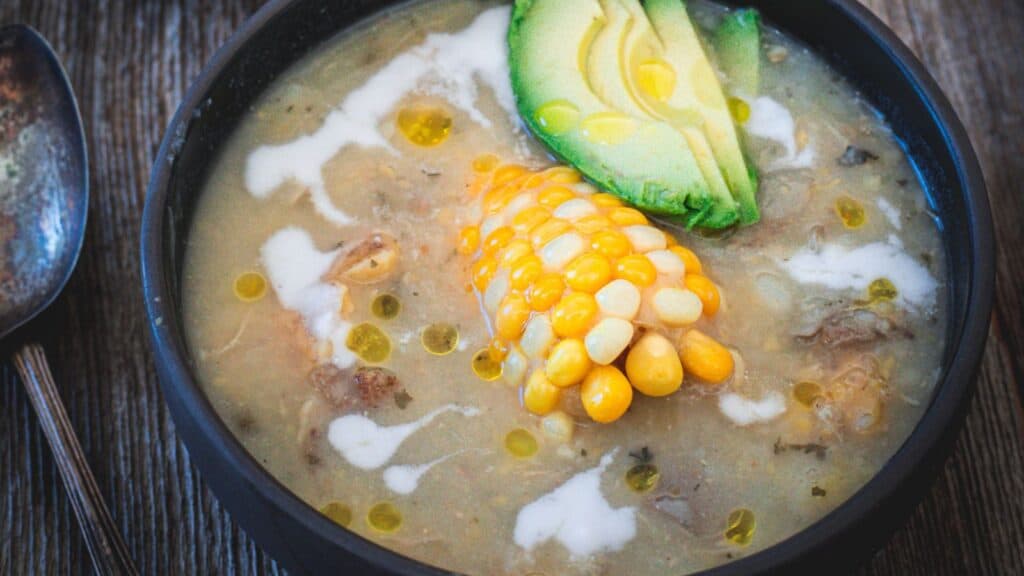 chicken ajiaco in a bowl with corn and avocado.