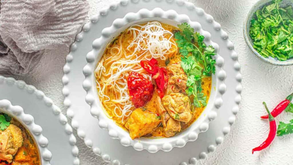 Chicken curry laksa in a white bowl.