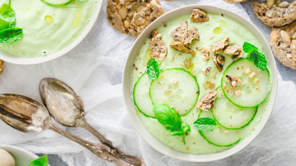 Cucumber gazpacho in bowls with crumbled crackers as garnish.