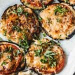 Eggplant tomato stacks on white plate.