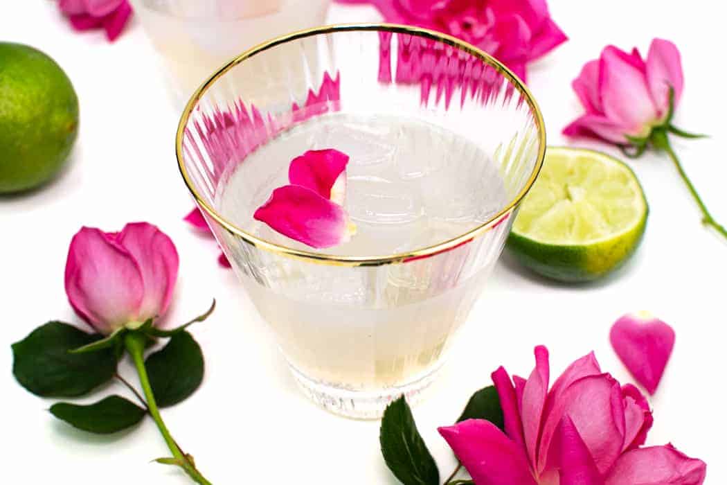 a gimlet garnished with pink rose petals.