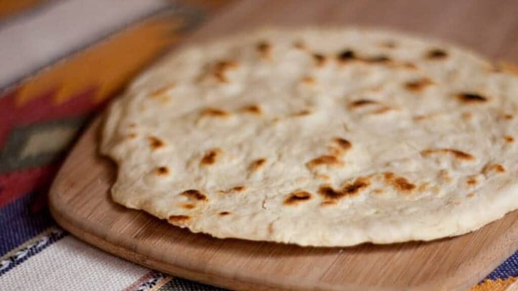 Flour tortillas on a wooden cutting board.