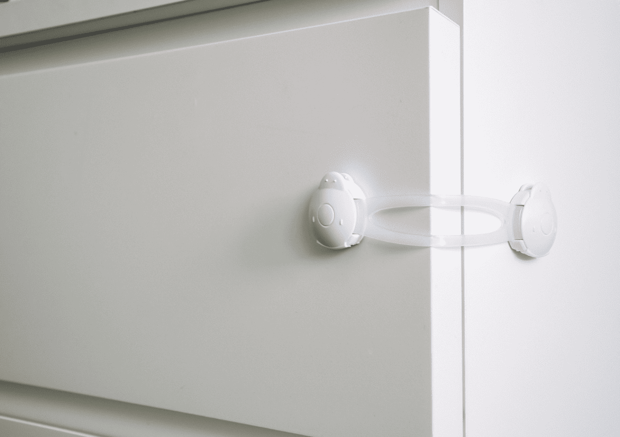 A safety latch locking a dresser drawer.