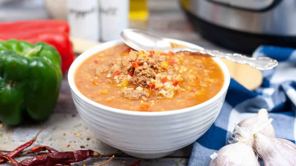 Stuffed pepper soup in a white bowl with a spoon.