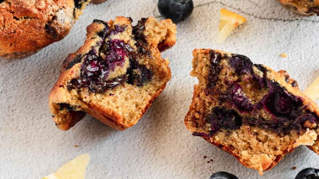 Lemon and blueberry muffin halves with lemon and blueberries.