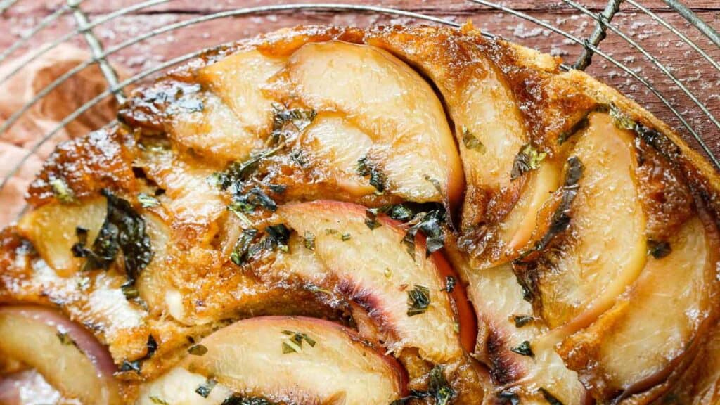 Nectarine basil upside down cake on wire rack.