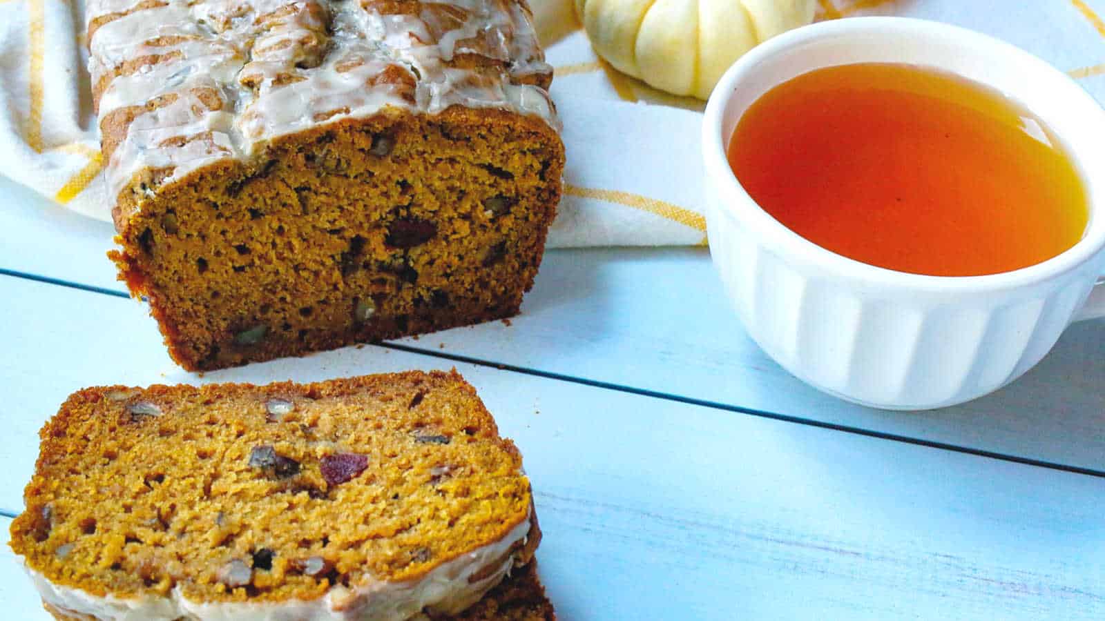 Iced pumpkin cranberry bread with a cup of tea.