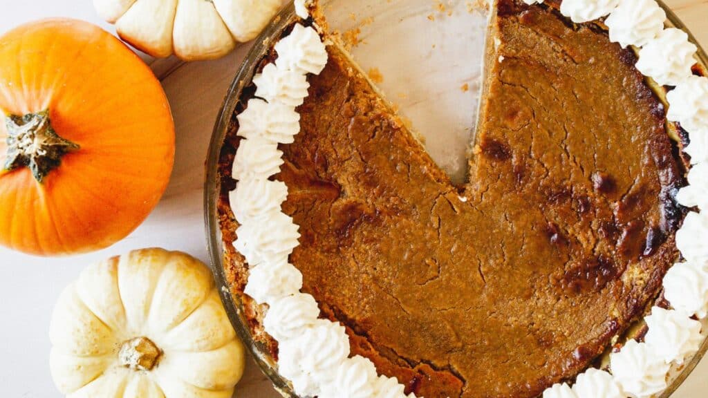 overhead view of pumpkin pecan pie with a slice missing