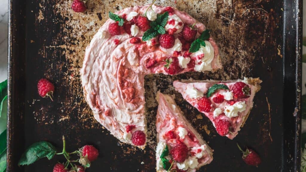 overhead of sliced raspberry cheesecake.