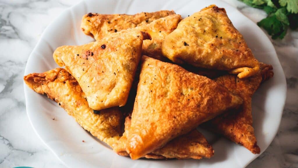 crispy vegetarian samosas. buttermilk chicken and potatoes on a plate.