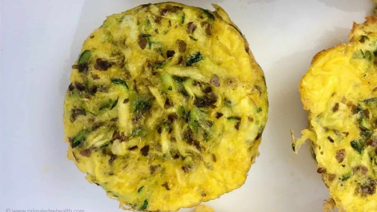 Scrambled egg muffins with zucchini and dulse flakes on white plate.