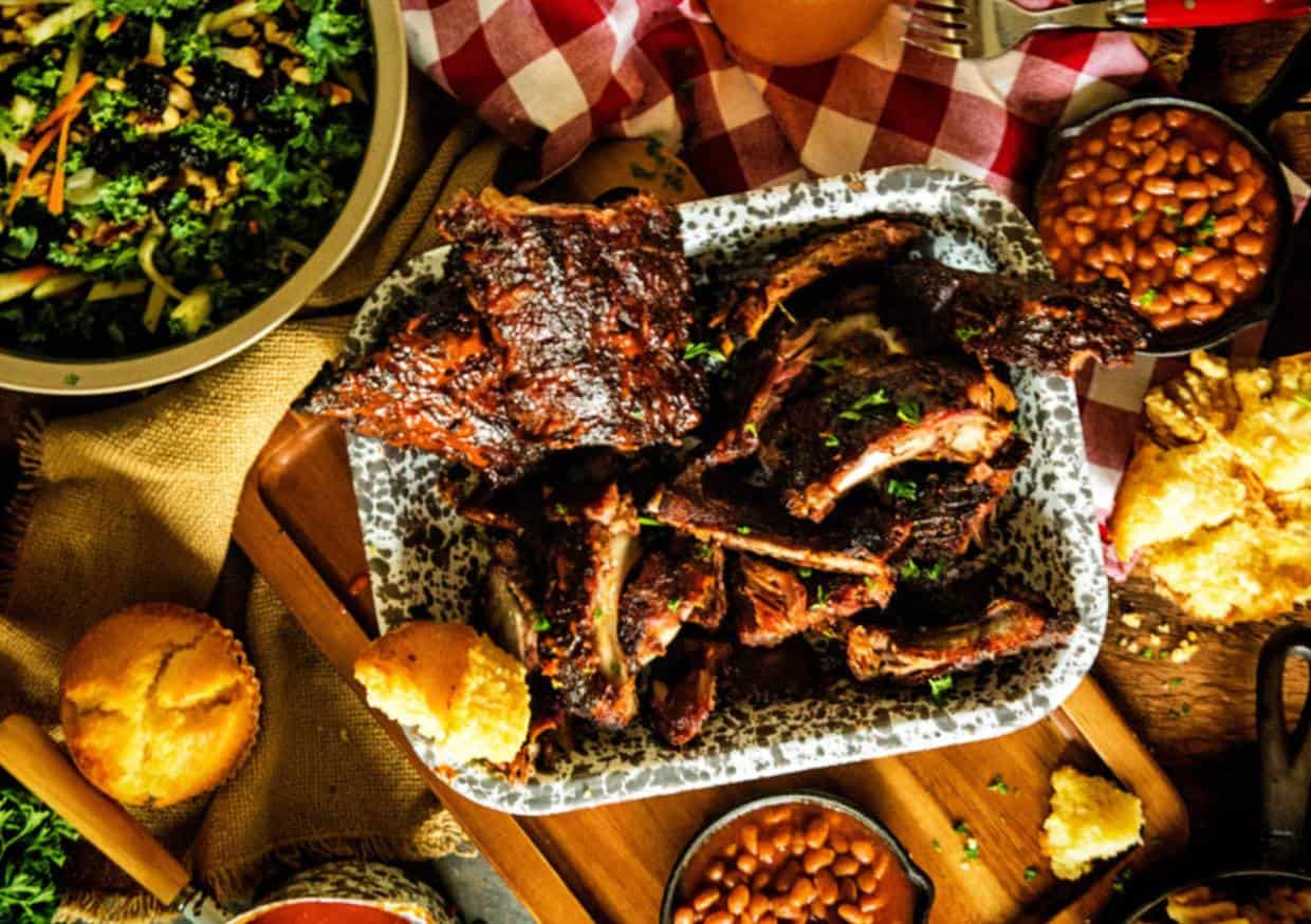 Platter of smoked ribs with side dishes.