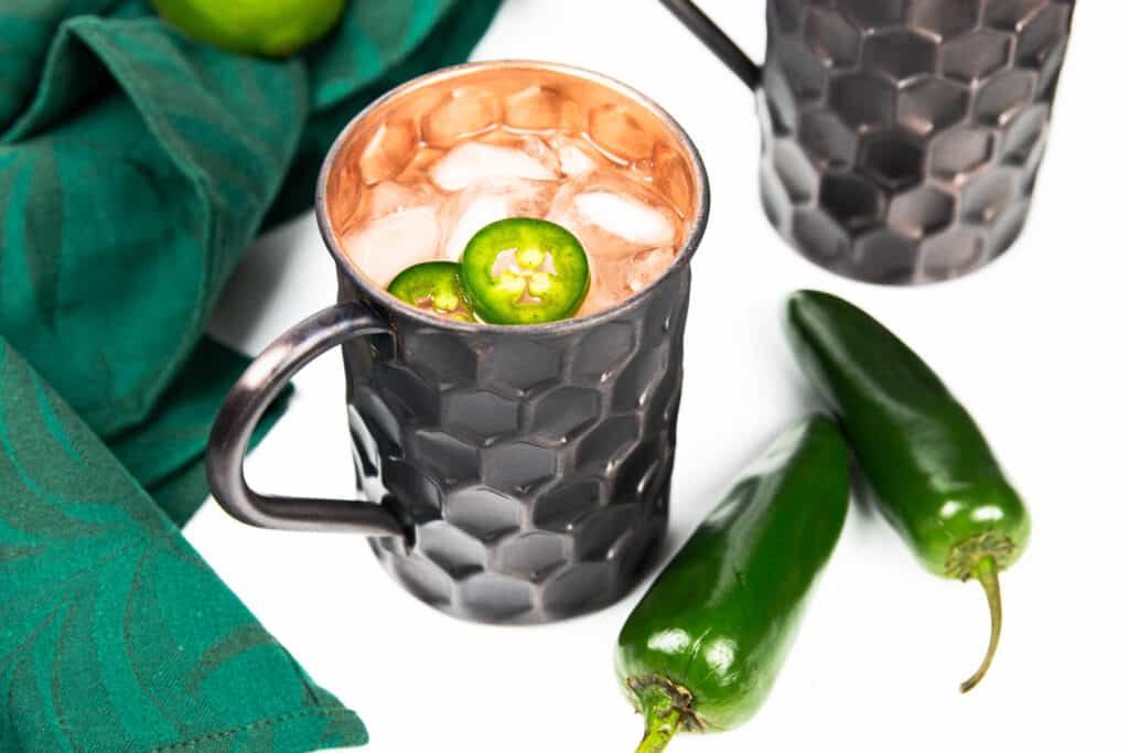 A jalapeño Moscow mule in a black and copper mug.