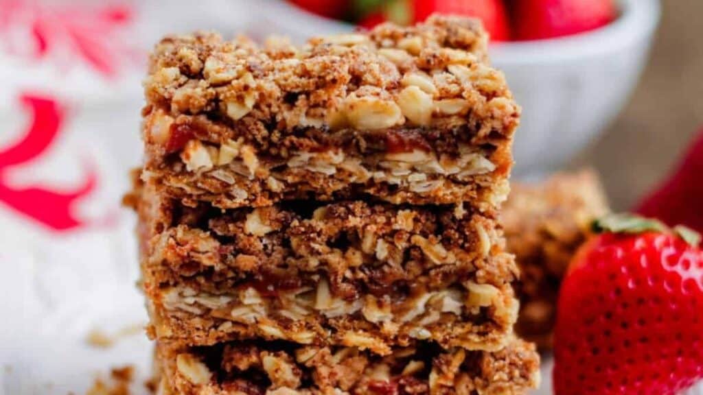 A stack of strawberry crumble bars on a plate.