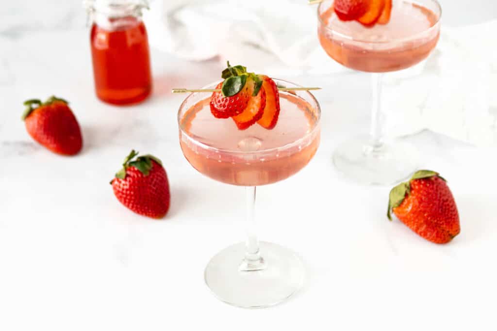 Two strawberry martinis on a marble background.