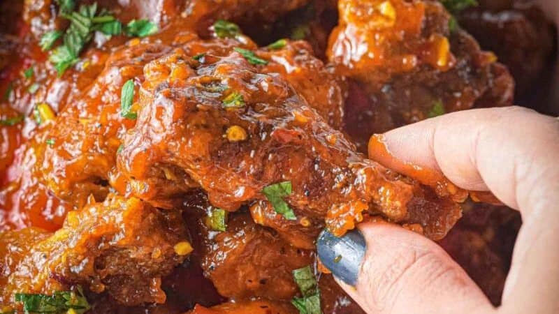 Grabbing a sweet chili wing out of a bowl.