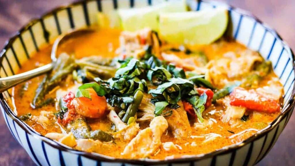 Thai chicken curry in a bowl on a wooden table.