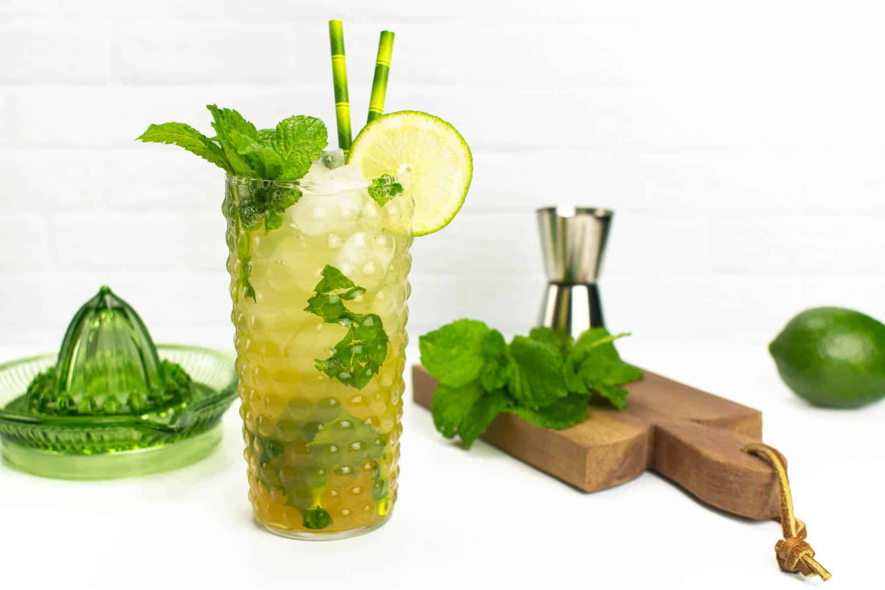 A virgin mojito on a wooden board with mint and a lime.