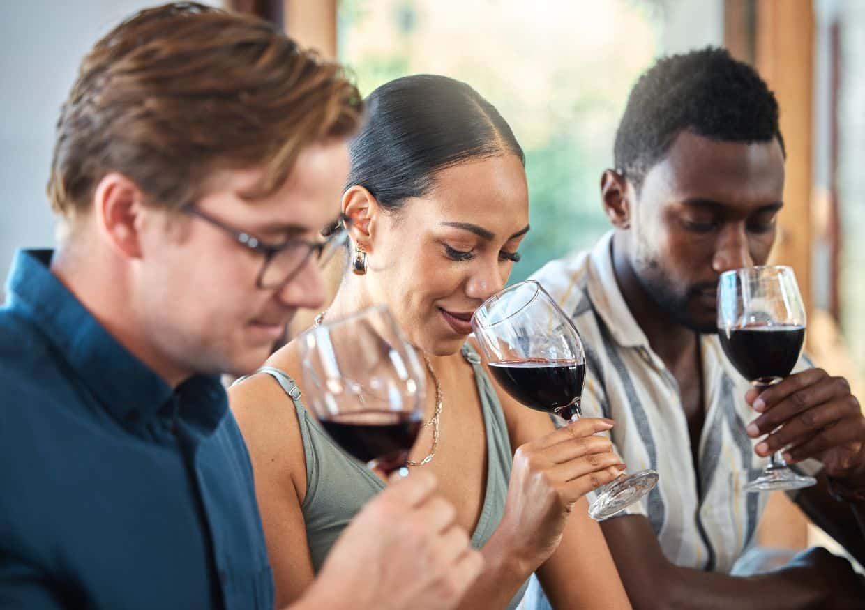 People smelling wine on a wine tasting tour.