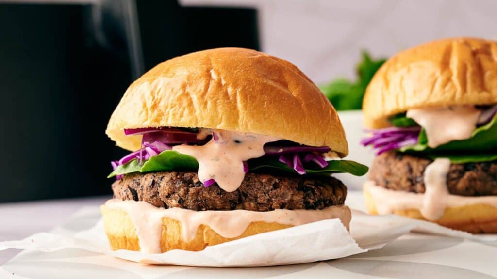 Two homemade black bean burgers in buns ready to eat.