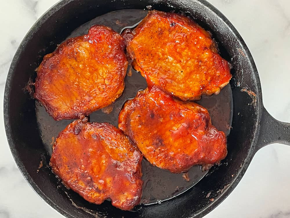 BBQ Pork Chops in a cast iron frying pan. 