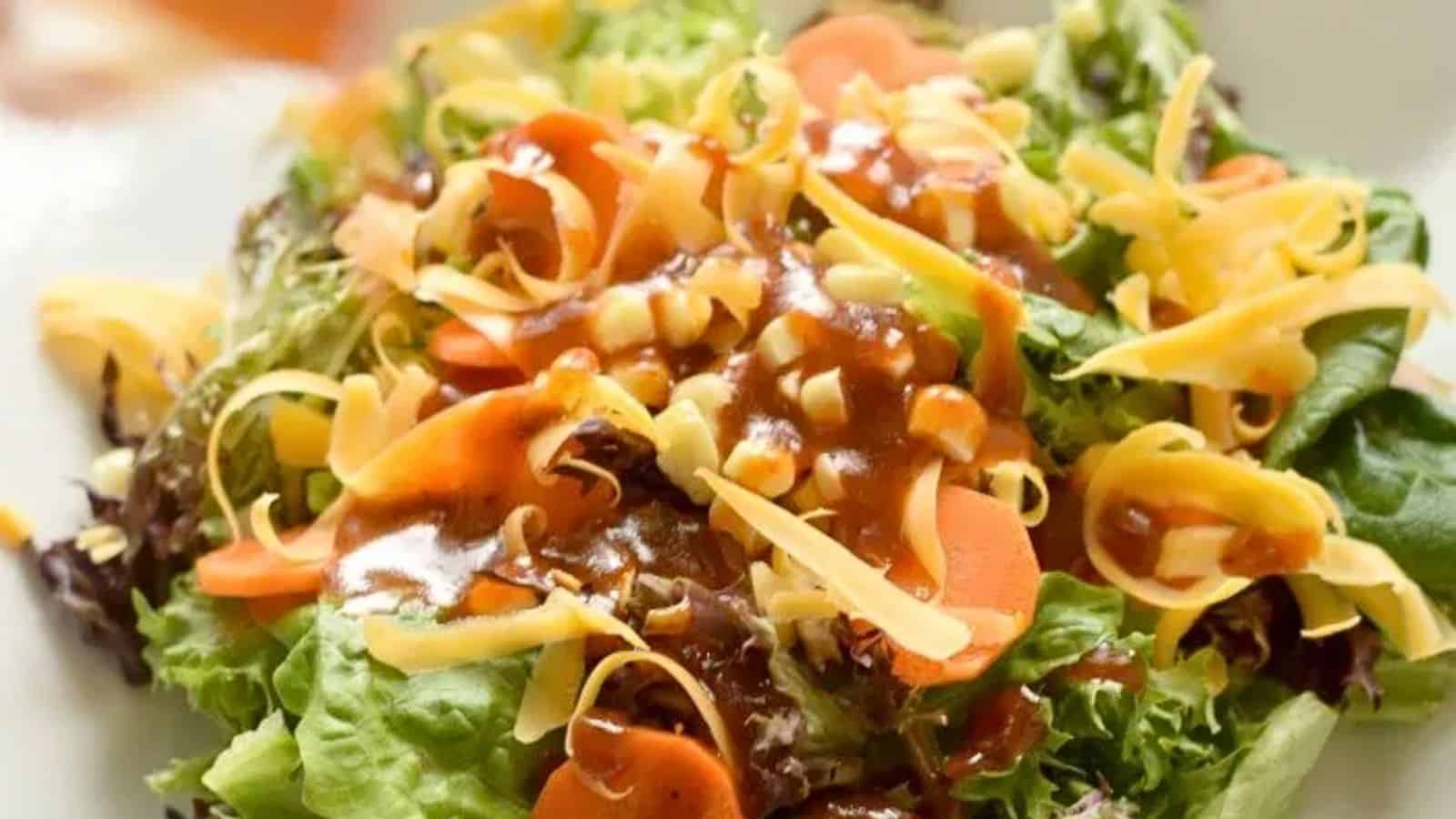Image shows a closeup of a salad with corn, carrots, cheese, and BBQ Vinaigrette.