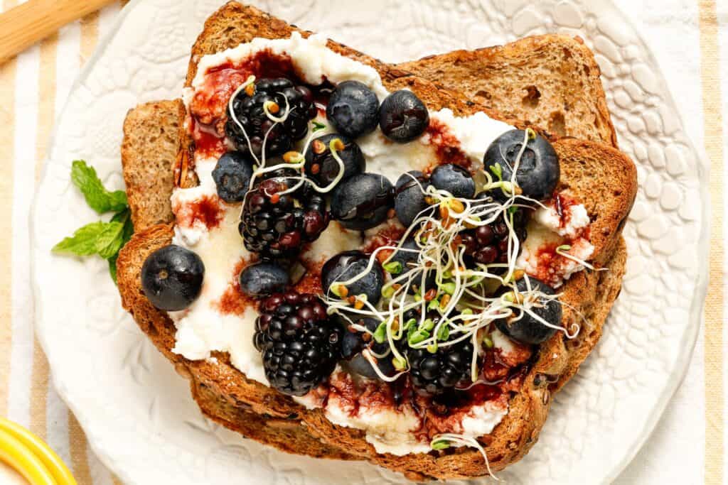 Ricotta toast with berries on a saucer.