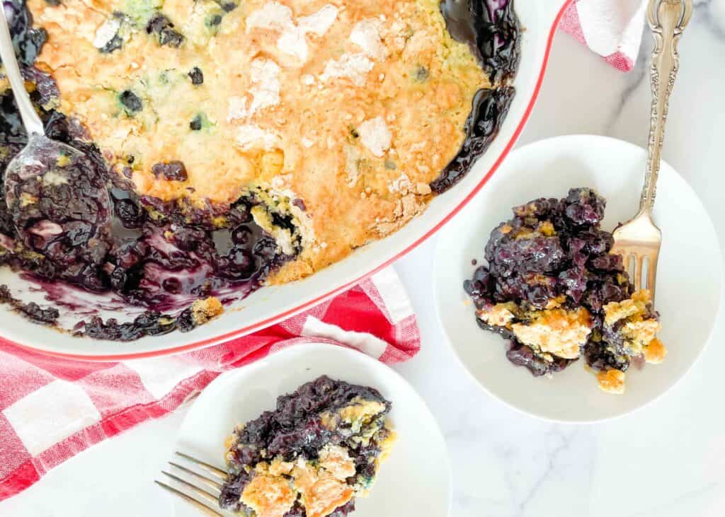 Blueberry cake in the pan and on two plates.